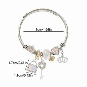 Detail of stainless steel charm bracelet with pink enamel heart, crown and pearl charms
