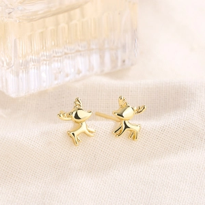 Boucles d'oreilles cerf dorées polies en pleine course sur un tissu texturé doux