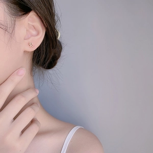 Boucles d'oreilles cerf en argent 925 doré portées par un mannequin sur l'oreille