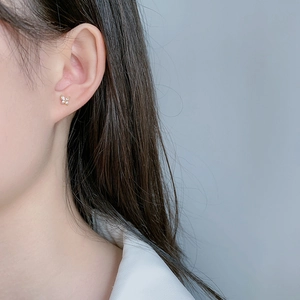 Elegant butterfly stud earrings with sparkling zircon crystals worn on a female ear