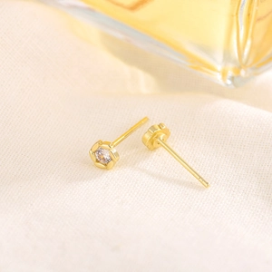 Elegant gold S925 mini flower stud earrings with clear zircon center on textured fabric
