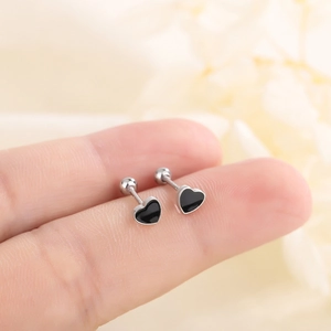 Boucles d'oreilles cœur noir en argent S925 avec fermoir à vis sécurisé sur la main
