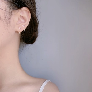 Close-up of minimalist s925 silver hollow heart stud earring worn by a model