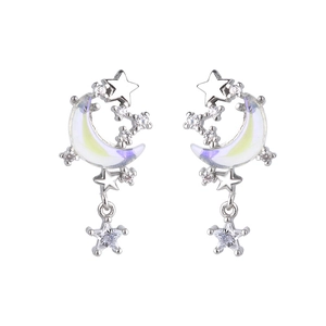 Gros plan sur les boucles d'oreilles lune argentées avec nacre irisante et pendentifs étoiles