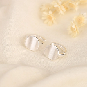 Minimalist S925 silver hoop earrings with brushed metal disks on beige linen background