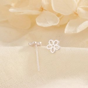 Minimalist S925 sterling silver flower stud earrings on natural linen background