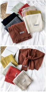 Detailed view of colorful knitted scarf shawls with ribbed edges and fabric labels
