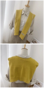 Detail of yellow knitted shawl wrap with ribbed hem and decorative white fabric label