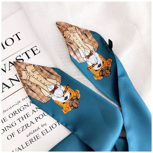 Detail of blue satin twilly scarf with cartoon dog illustration on fabric background