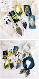 Detailed view of narrow silk scarves with various cartoon animal prints and vibrant colors