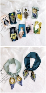 Detail of colorful silk scarves with cartoon animal prints on white fabric background