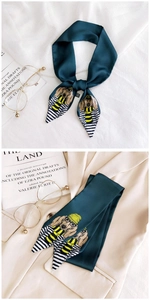 Detail of dark green skinny scarf with cute dachshund print on silk-like fabric