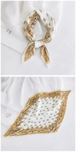 Detail of pleated silk scarf featuring beige and brown patterns with textured finish