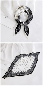 Detail of black and white paisley pleated silk scarf with elegant accordion folds