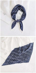 Close-up of pleated paisley silk scarf in dark blue with fine accordion edge texture