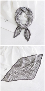 Detail of grey and black pleated satin scarf with vintage paisley print on linen