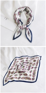 Detail of pleated floral silk scarf featuring purple patterns and navy scalloped edges