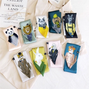 Silk-feel twilly scarves with cute animal illustrations displayed on a cream shirt