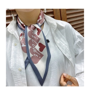 Close-up of a heart pattern twilly scarf styled as a neckerchief with a white shirt