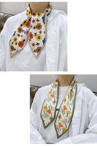 Detail of floral and leaf print twilly scarves with stylish color piping and silk texture