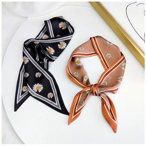 Detail of floral daisy pattern twilly silk scarves in black and caramel colors