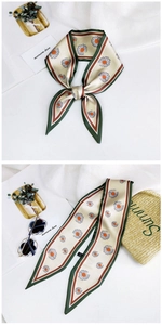 Detail of floral twilly scarf with daisy print and contrast border for summer style