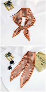 Detail of floral skinny scarf with white daisy prints on orange brown silk-like fabric