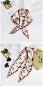 Detail of floral twilly scarf with daisy print and brown contrast edges on beach bag