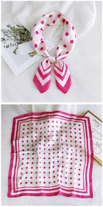 Detailed close-up of square silk scarf with pink polka dots and striped border details