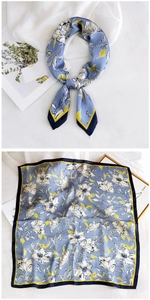 Detail of floral silk scarf showing blue botanical print and yellow contrast border