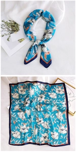 Detail view of 70cm square silk scarf with blue floral pattern and orange accents
