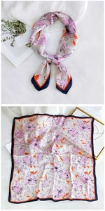 Detail of floral silk scarf showing soft pink flowers and contrast hemmed edges