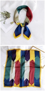 Detail of square silk scarf with geometric color blocks and vibrant satin texture