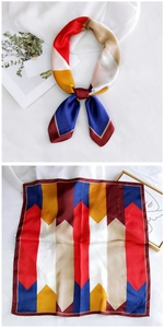 Detail of color-block geometric silk scarf showing satin texture and red hemmed edges