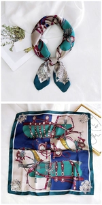 Detail of square silk scarf featuring equestrian motifs and vintage emerald green color