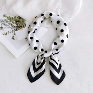 Silk-textured square scarf with black polka dots and stripe pattern tied in a bow