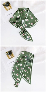 Detail of silk twilly scarf featuring white daisy print on dark green background