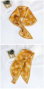 Detail of yellow daisy print twilly scarf with elegant floral pattern on silk-like fabric