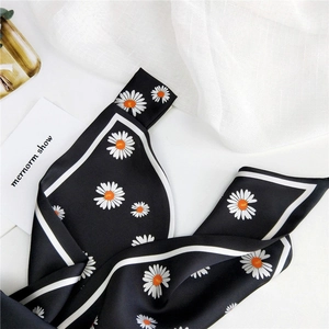 Elegant black silk skinny scarf with white daisy floral pattern and smooth glossy finish