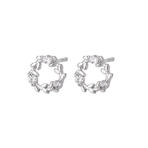 Macro shot of silver wreath stud earrings featuring intricate leaf design and zircon stones