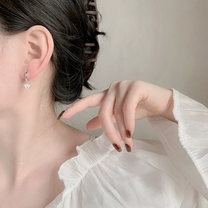 Orecchini a cerchio con ciondolo a orsetto in argento indossati per un look alla moda