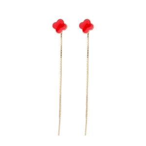 Detailed view of gold tassel earrings featuring red clover charms with beaded edges