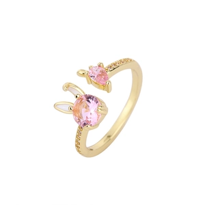 Golden bunny ring with pink zircon and enamel ears on a minimalist open band style