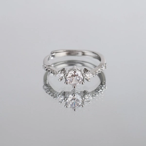 Elegant silver open ring featuring a sparkling central zircon and side stones on a reflective surface