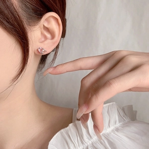 Süße rosa herzförmige Ohrstecker mit Kristallen auf Silberbasis, von einem Model getragen