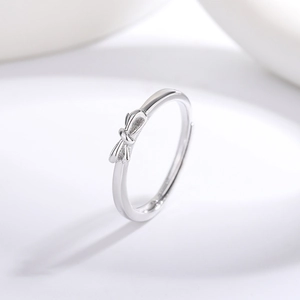 Elegant adjustable silver bow ring with polished finish in a minimalist jewelry design
