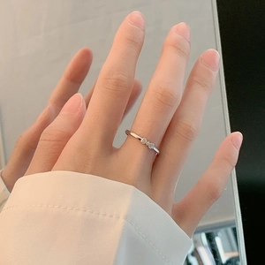 Minimalist S925 sterling silver bow ring with heart-cut crystals on a model's hand