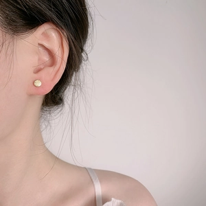 Minimalist s925 gold stud earring with Fu character engraving shown on ear