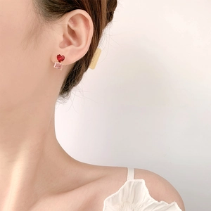Boucles d'oreilles cœur en cristal bicolore avec pierres rouges et roses portées