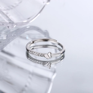 Minimalist S925 butterfly open ring with sparkling stones on a reflective surface